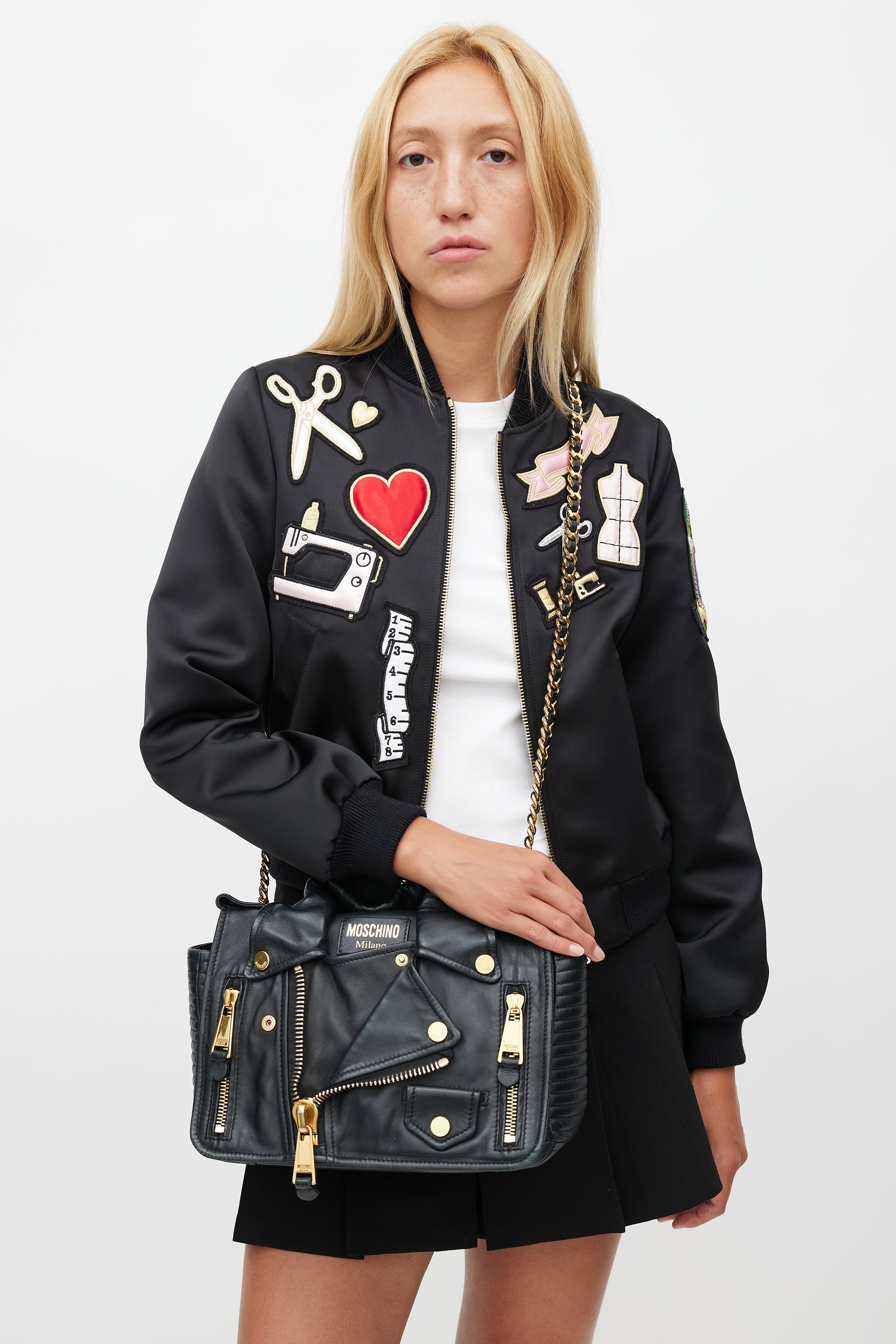 Black Moschino Biker Jacket Bag with gold hardware in an editorial setting.