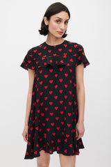 black dress with red hearts Long Wrap star motifs Square neckline Fitted at bodice then gathers from waistline into skirt Maxi length skirt Puff sleeves with frill cuff with ties in self fabric Zip fastening in centre back with large decorative tie Fabric content Red Valentino // Black &